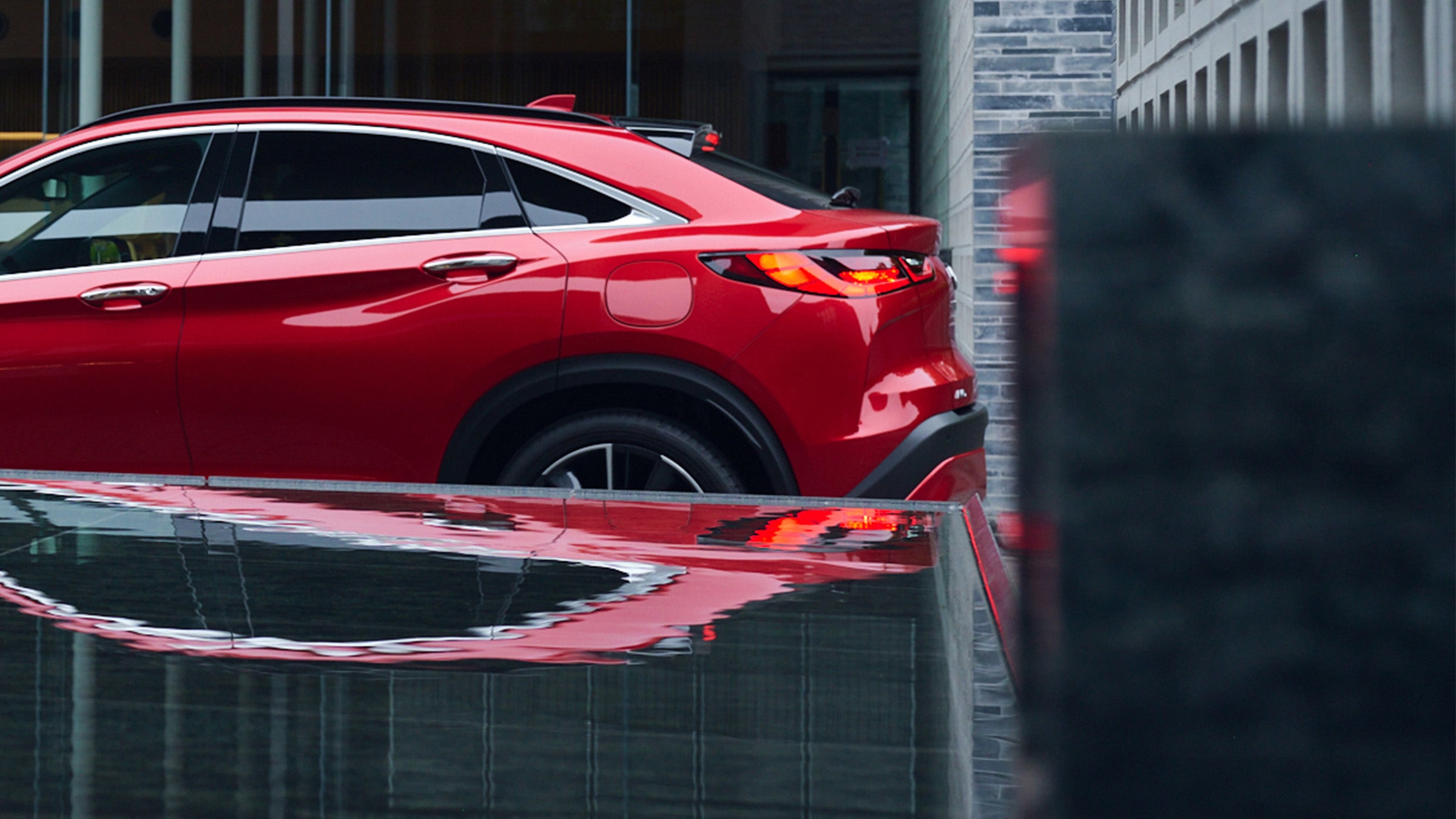 Reflection of a red 2024 INFINITI QX55 crossover